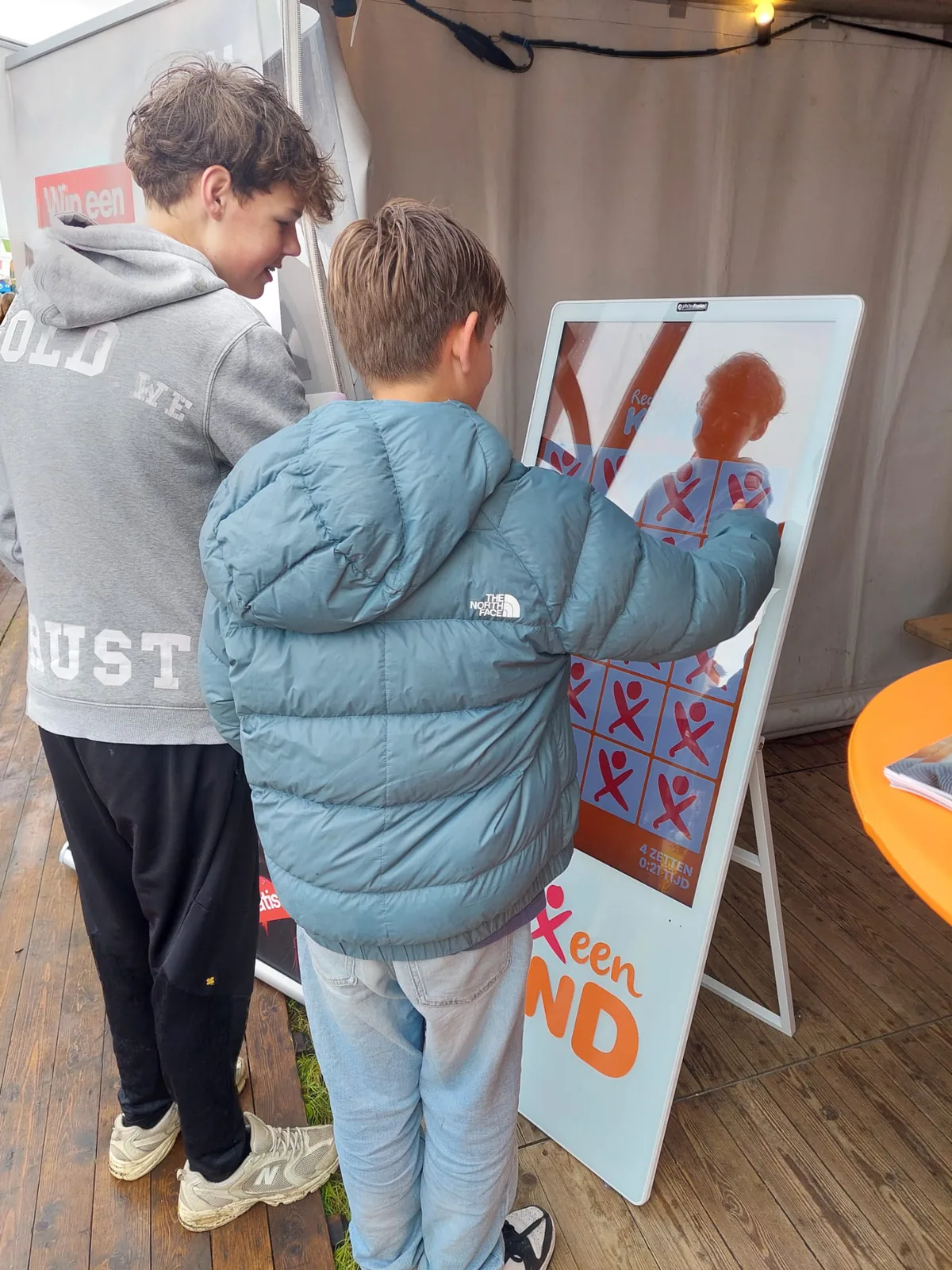 Twee kinderen spelen het digitale memoryspel van Red een Kind op een touchscreen