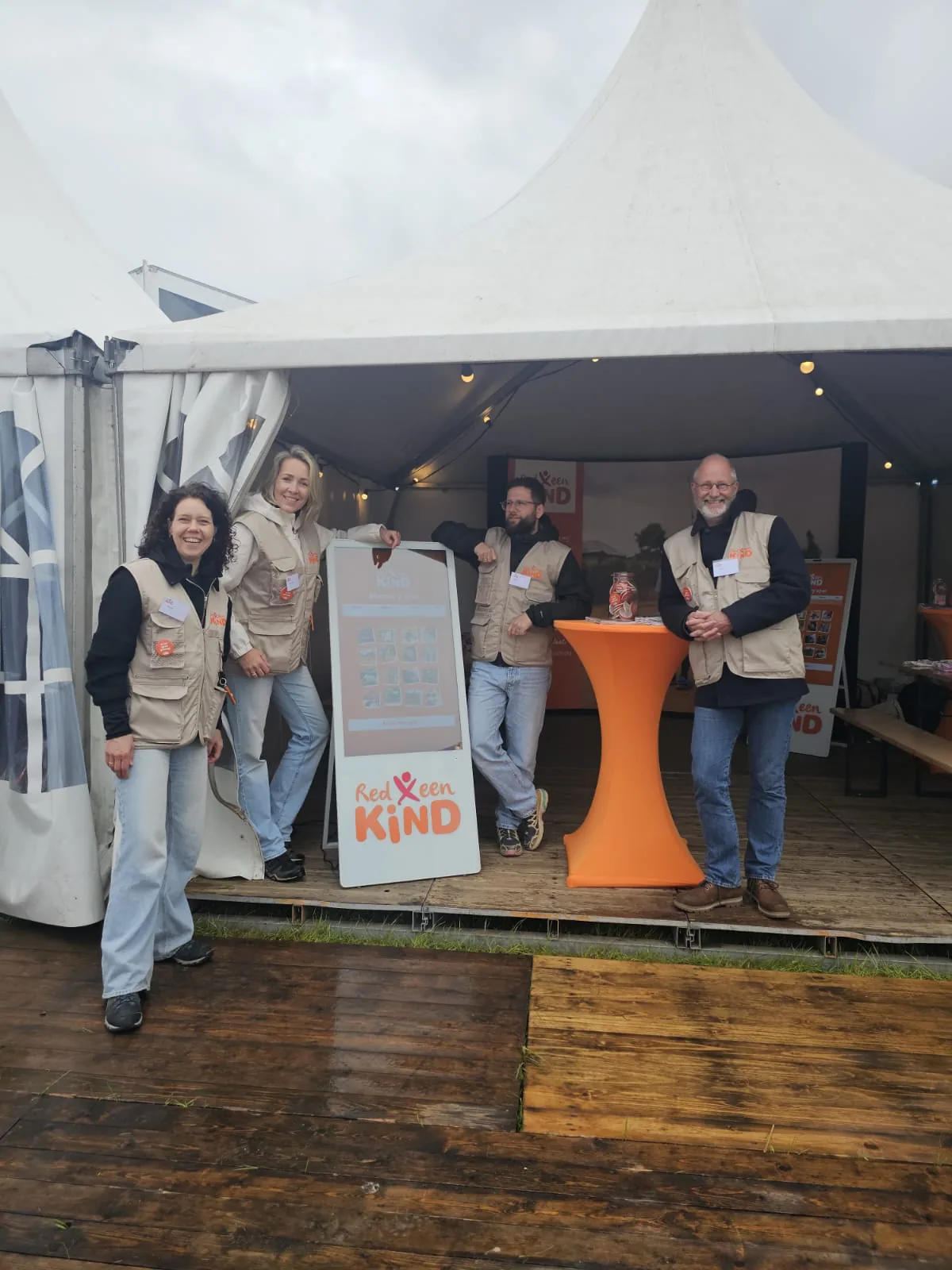 Het team van Red een Kind bij het touchscreen met het memoryspel op een evenement